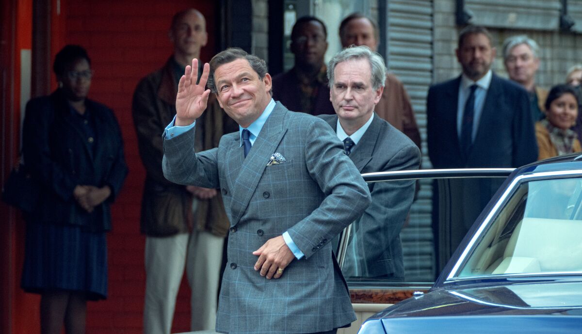 A man waves as he gets out of a car "The crown."