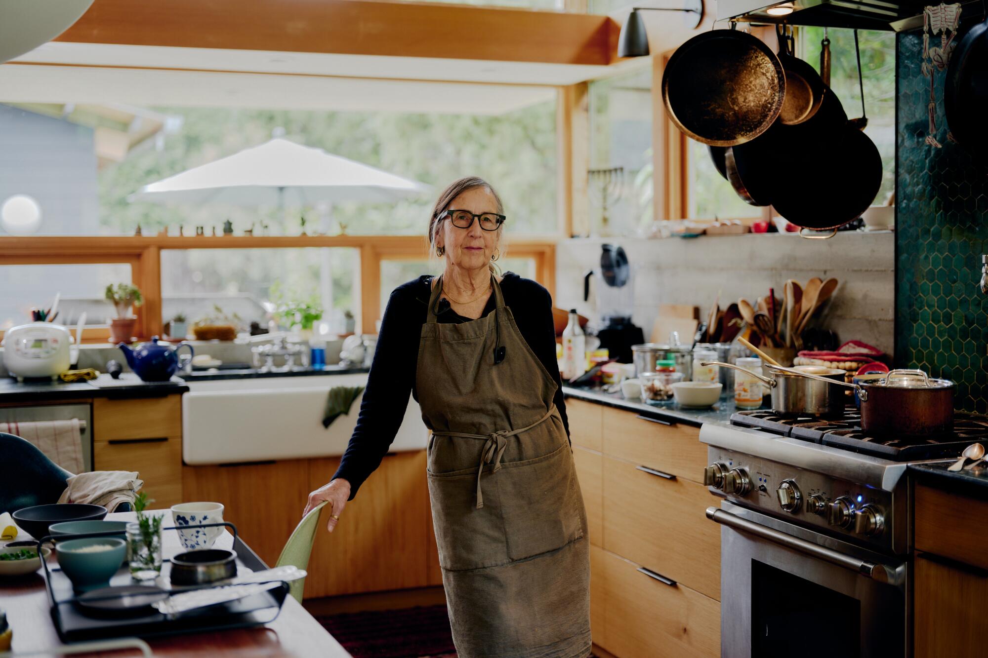 A woman stands in her home kitchen