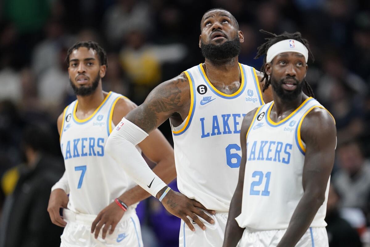 Lakers teammates, from left, Troy Brown Jr., LeBron James and Patrick Beverley wait for play to resume.