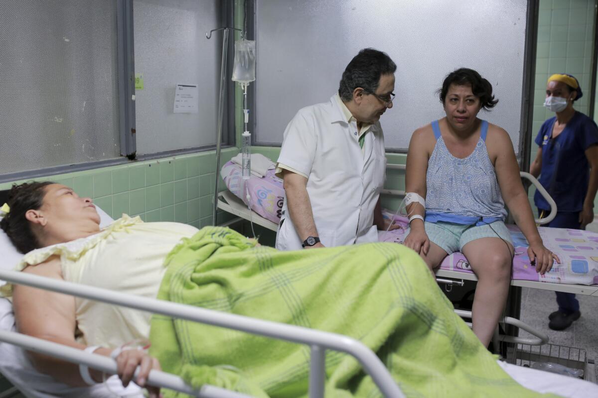 En esta imagen del 11 de febrero de 2016, el neúrologo Jairo Lizarazo habla con su paciente Daysi Mendoza, que se recupera del síndrome de Guillain-Barre en el hospital Erasmo Meoz en Cúcuta, en el estado Norte de Santander, Colombia. En esta enfermedad, el que el sistema inmune ataca el sistema nervioso, causando debilidad muscular y en ocasiones parálisis. A Mendoza, una venezolana que cruzó la frontera para recibir tratamiento, se le diagnosticó el virus del zika días antes de mostrar síntomas de Guillain-Barre. Desde el inicio del brote de zika se han diagnosticado en el estado de Norte de Santander 10 veces más casos del síndrome que la media anual. (AP Foto/Ricardo Mazalan)