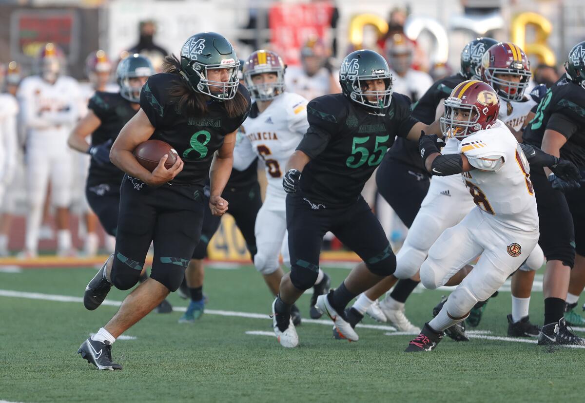 Costa Mesa quarterback Nick Burton (8) is forced out of the pocket and pressured by Estancia linebackers on Friday.