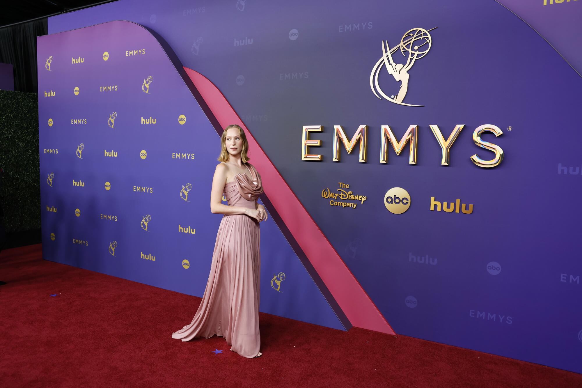 Hannah Einbinder wears a pink pleated gown. 