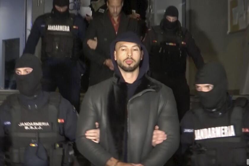 In this grab taken from video released by Observator Antena 1, Social Media personality Andrew Tate is led away by police, in the Ilfov area, north of Bucharest, Romania, Thursday, Dec. 29, 2022. Romanian news outlets are reporting that divisive social media personality Andrew Tate has been arrested on charges of human trafficking and rape. The reports say Tate and his brother Tristan were detained late Thursday. Romania’s anti-organized crime agency said two British citizens and two Romanians are accused of being part of an organized crime group, human trafficking and rape. (Observator Antena 1 via AP)