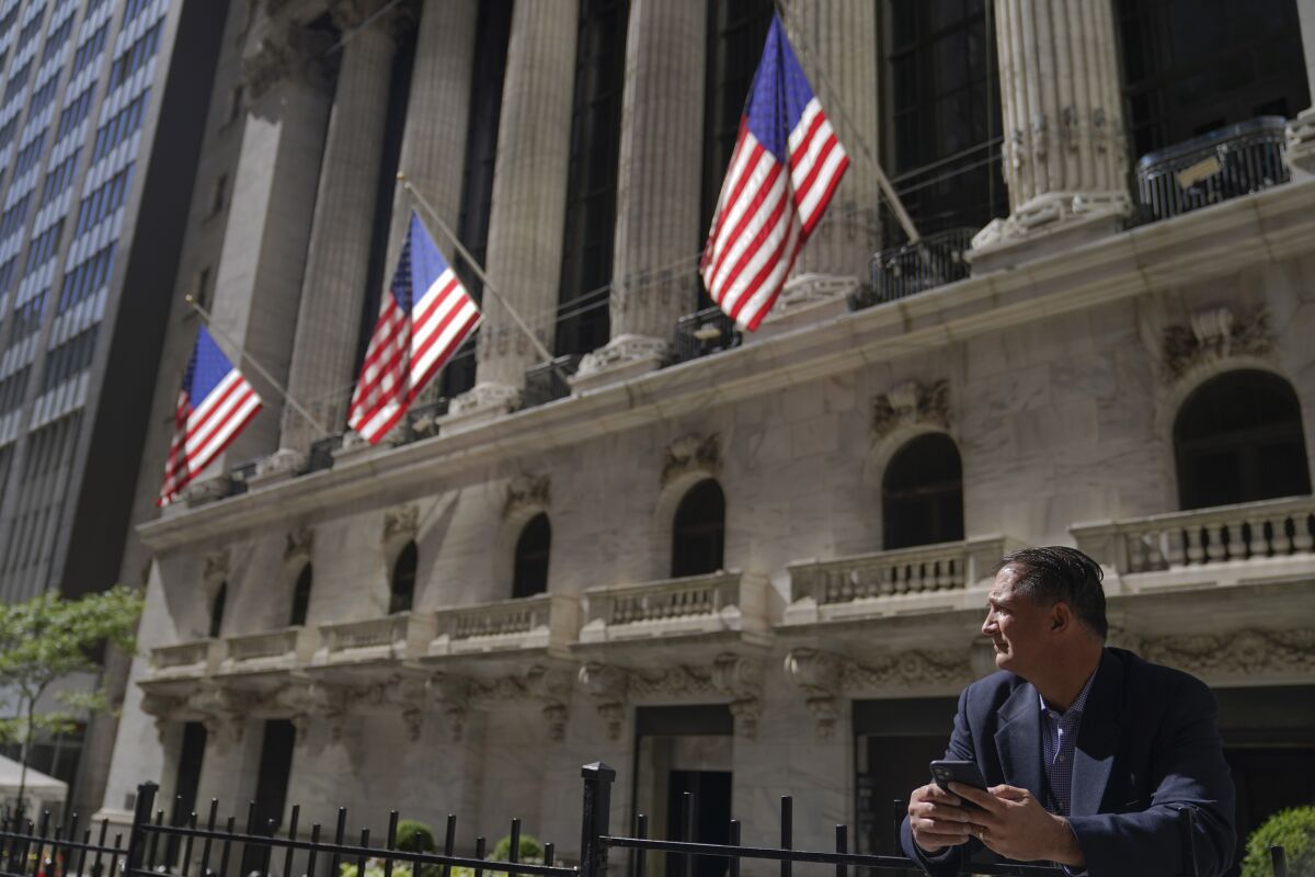 A man stands outside the New York Stock Exchange.