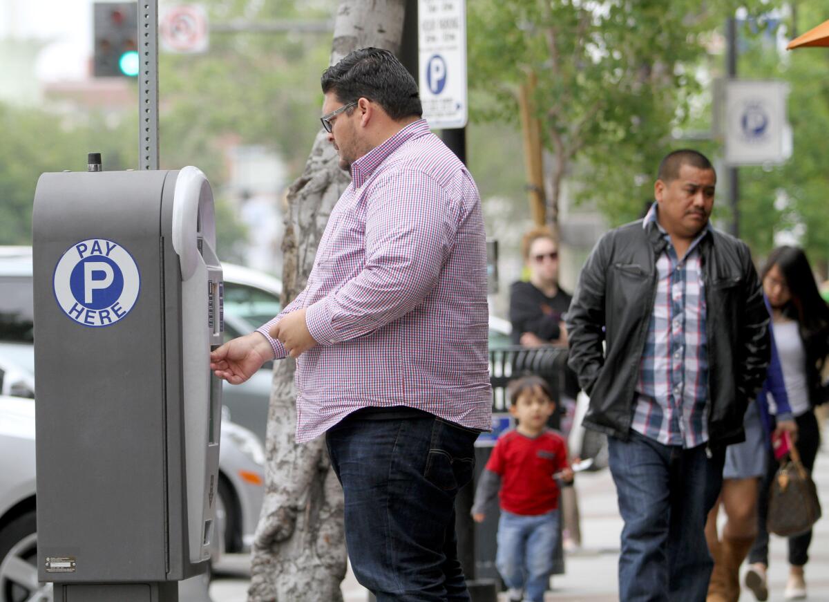 A man pays for his parking on the 300 block of N. Brand Blvd. in Glendale on Wednesday, May 11, 2016. The current parking rate is $1 per hour.