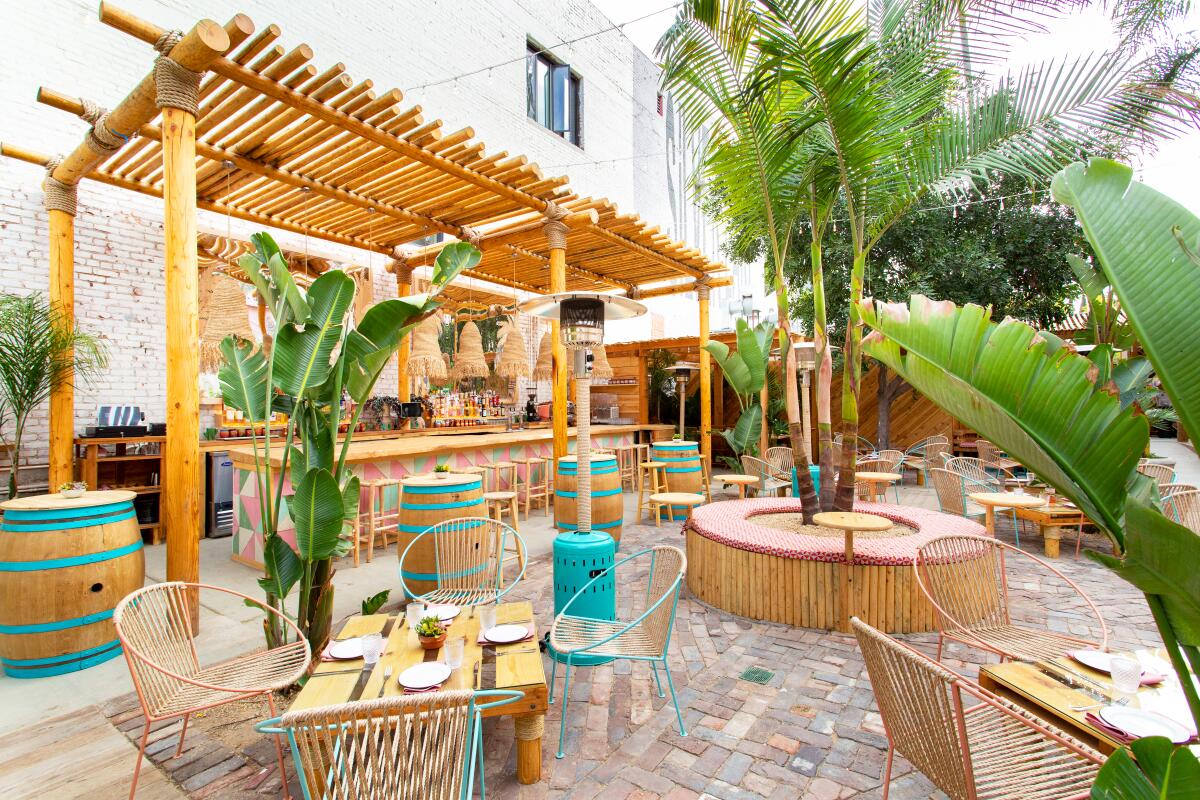 A restaurant's outdoor patio featuring tropical Mexican decor and plants.