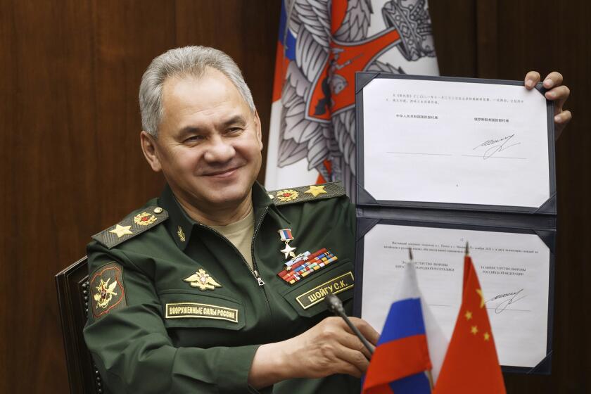 FILE - In this photo released by the Russian Defense Ministry Press Service, Russian Defense Minister Sergei Shoigu shows his signature under a roadmap for military cooperation between Russia and China during a video call with Chinese Defense Minister Wei Fenghe in Moscow, Russia, Tuesday, Nov. 23, 2021. The U.S. says Russia has asked China to provide military assistance for its war in Ukraine, and that China has responded affirmatively. Both Moscow and Beijing have denied the allegation, with a Chinese spokesperson dismissing it as “disinformation.” (Vadim Savitskiy/Russian Defense Ministry Press Service via AP)