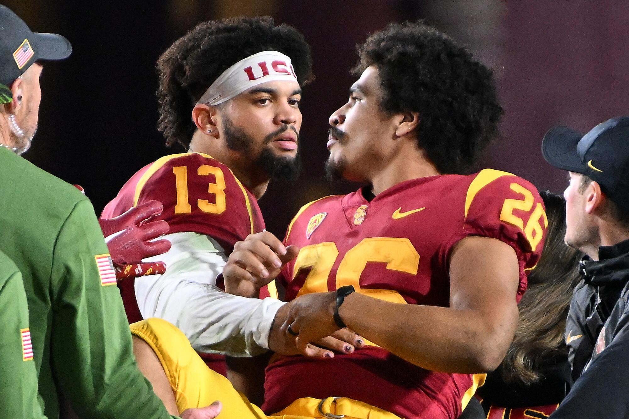 Injured USC running back Travis Dye is consoled by quarterback Caleb Williams as he's carted off the field.