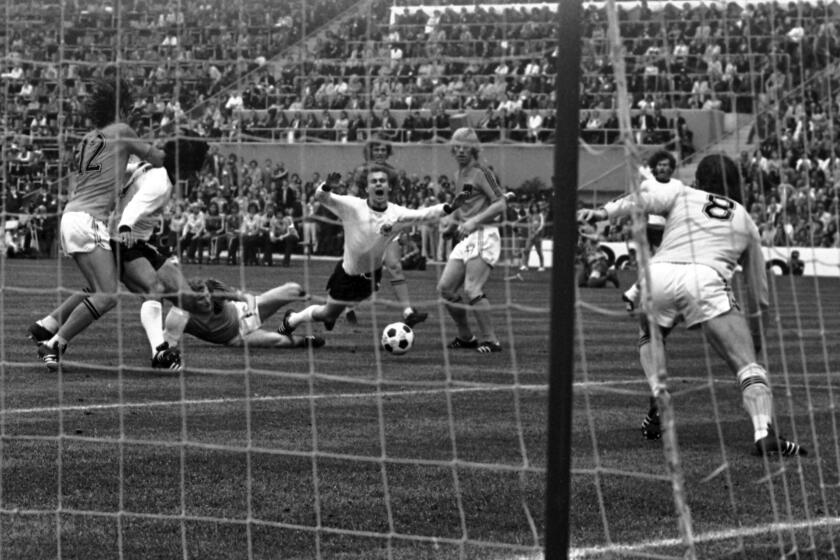 FILE - West Germany's Bernd Hölzenbein, center, is brought down by Holland's Wim Jansen in the penalty area during the Soccer World Cup Final in Munich, Germany on July 7, 1974. English Referee Jack Taylor, unseen, awarded a penalty kick which was converted by the Germans. Hölzenbein, who won a crucial penalty in West Germany's victory over the Netherlands in the 1974 World Cup final, has died. He was 78. Hölzenbein's former club Eintracht Frankfurt said in a statement Tuesday, April 16, 2024, that he died Monday while with his family, without giving further details. (AP Photo/Fra, file)