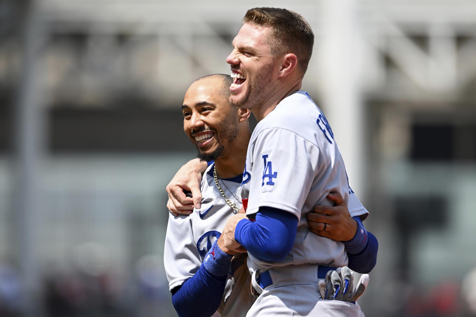 Dodgers teammates Mookie Betts, left, and Freddie Freeman laugh during a game against the Cleveland Guardians.