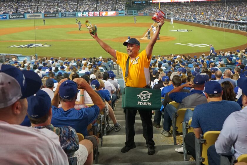 LOS ANGELES - OCTOBER 6, 2017: Robert E. Sanchez, who has been working at Dodger Stadium since 1974, sells peanuts and Cracker Jacks during the first game of the National League Division Series.