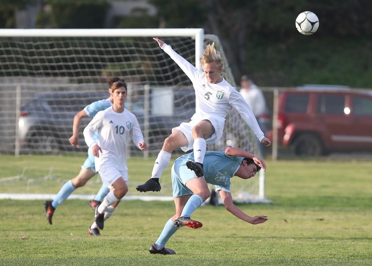 Edison's Marcus Henze (5), shown being upended against Corona del Mar on Jan. 11, scored the eventual game-winning goal for the Chargers on Saturday in the Hawks Invitational semifinals.