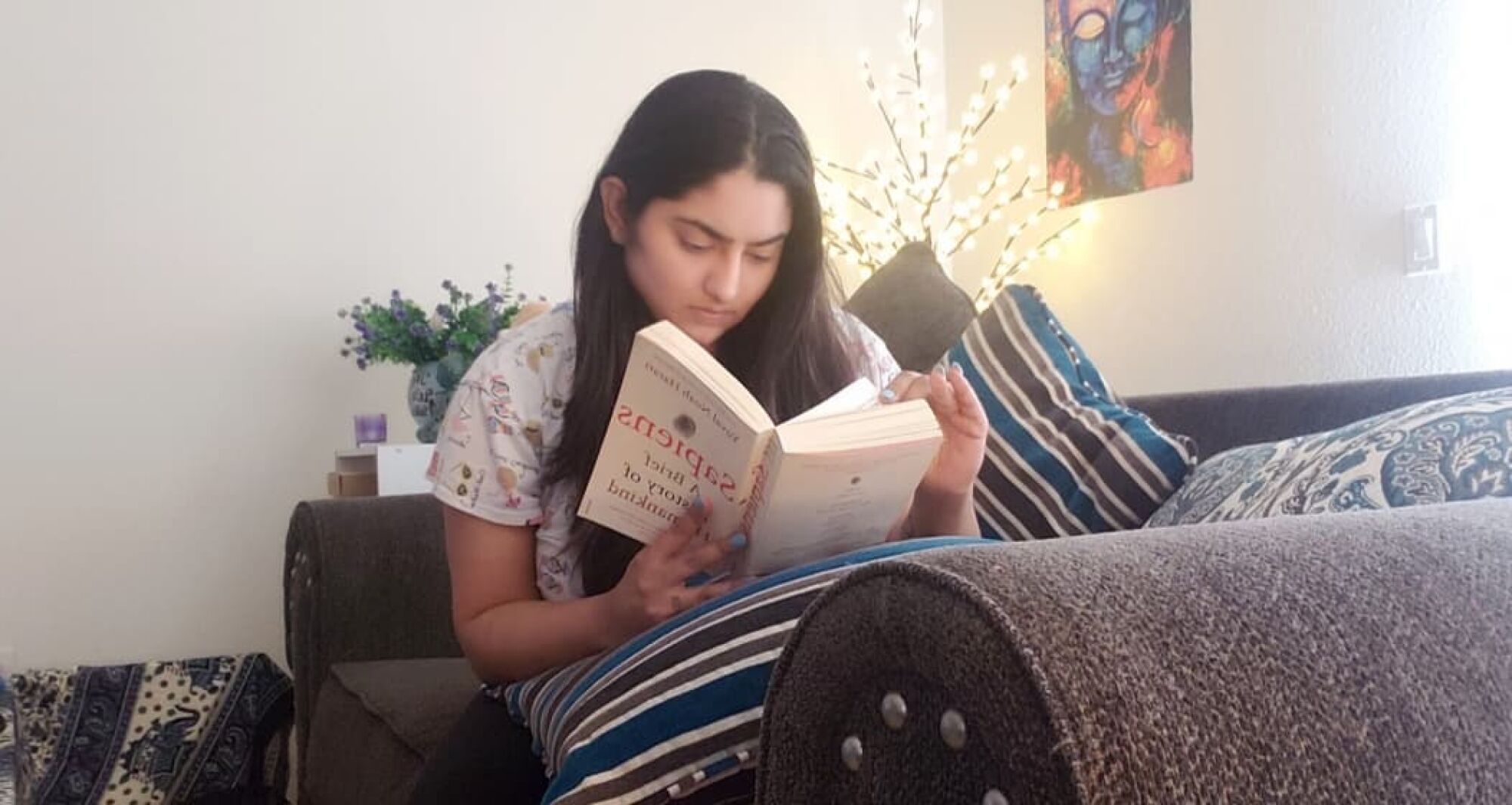 Tanya Sawhney reads at her home Monday night.
