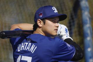 Dodgers' Shohei Ohtani warms up near the batting cage before taking some swings during spring training on Feb. 14, 2024.