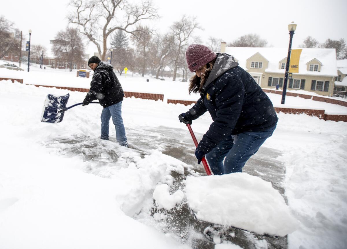 Francis Garza, Tina Longoria shovel snow at University of Northern Colorado
