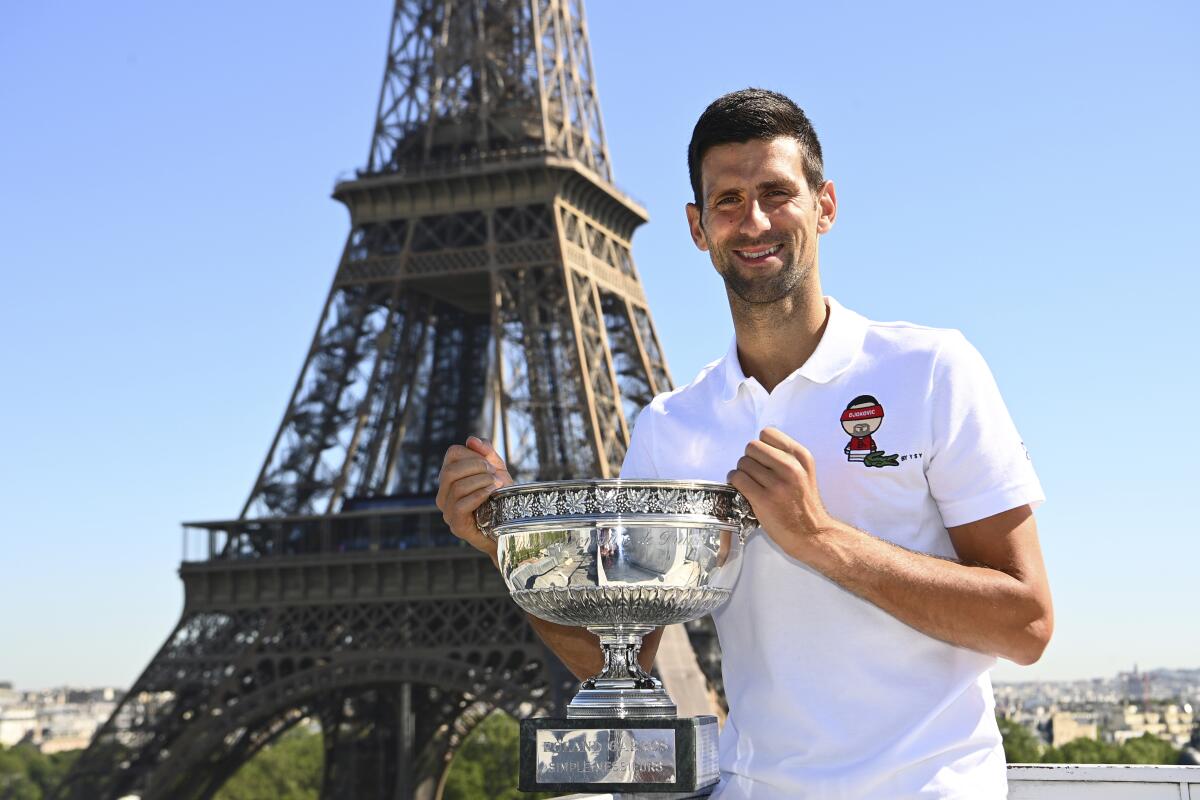Novak Djokovic posa con el trofeo de campeón del Abierto de Francia frente a la torre Eiffel.