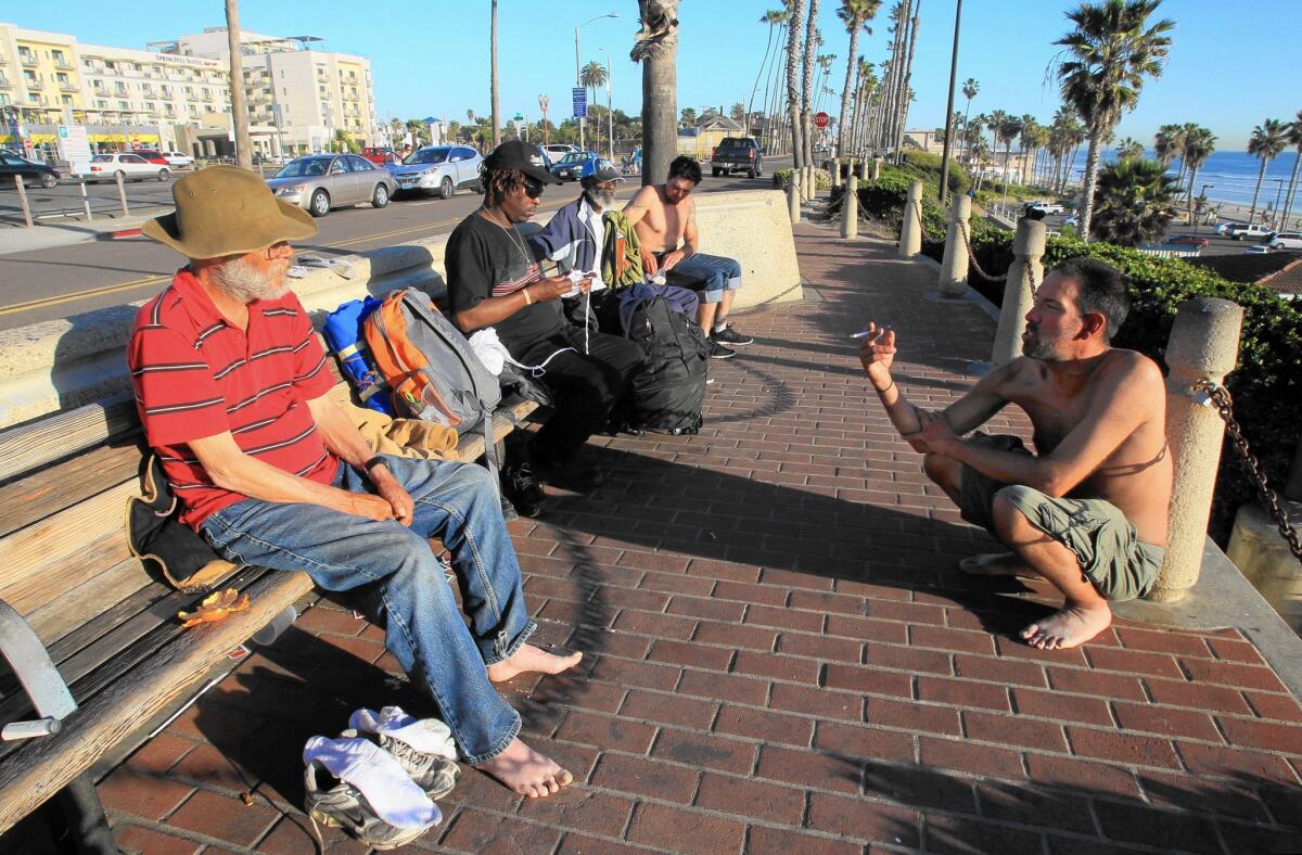 A group of homeless men hang out near the Oceanside pier. “We just try to seek out safety,” said one.