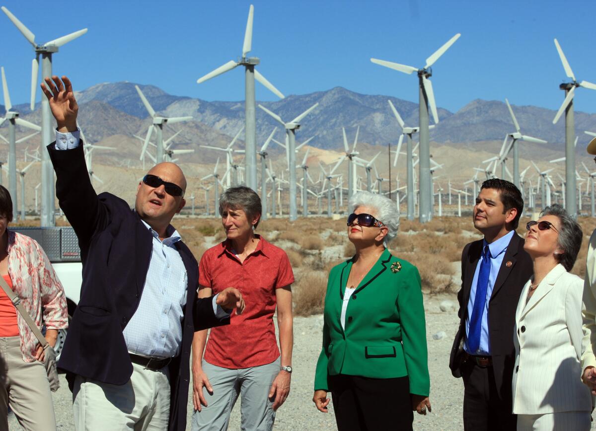 Rep. Grace Napolitano, center in green, tours a wind farm in Palm Springs. She is one of at least five California members of Congress who live outside the boundaries of their districts.