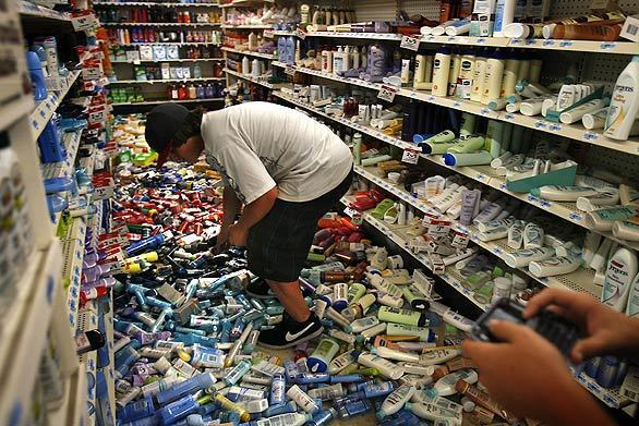 Corey Dixon, 14, sifts through deodorant to purchase from Kmart in Diamond Bar during the aftermath of a 5.4-magnitude earthquake. Several aisles were covered with merchandise that fell from the shelves. (An earlier version of this caption said the Kmart was in Chino Hills.)