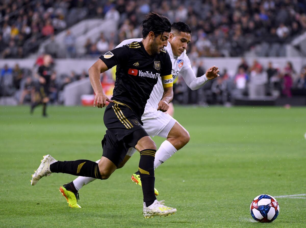 Carlos Vela #10 of Los Angeles FC is chased by Victor Ulloa #8 of FC Cincinnati during a 2-0 Los Angeles FC win at Banc of California Stadium on April 13, 2019 in Los Angeles, California.