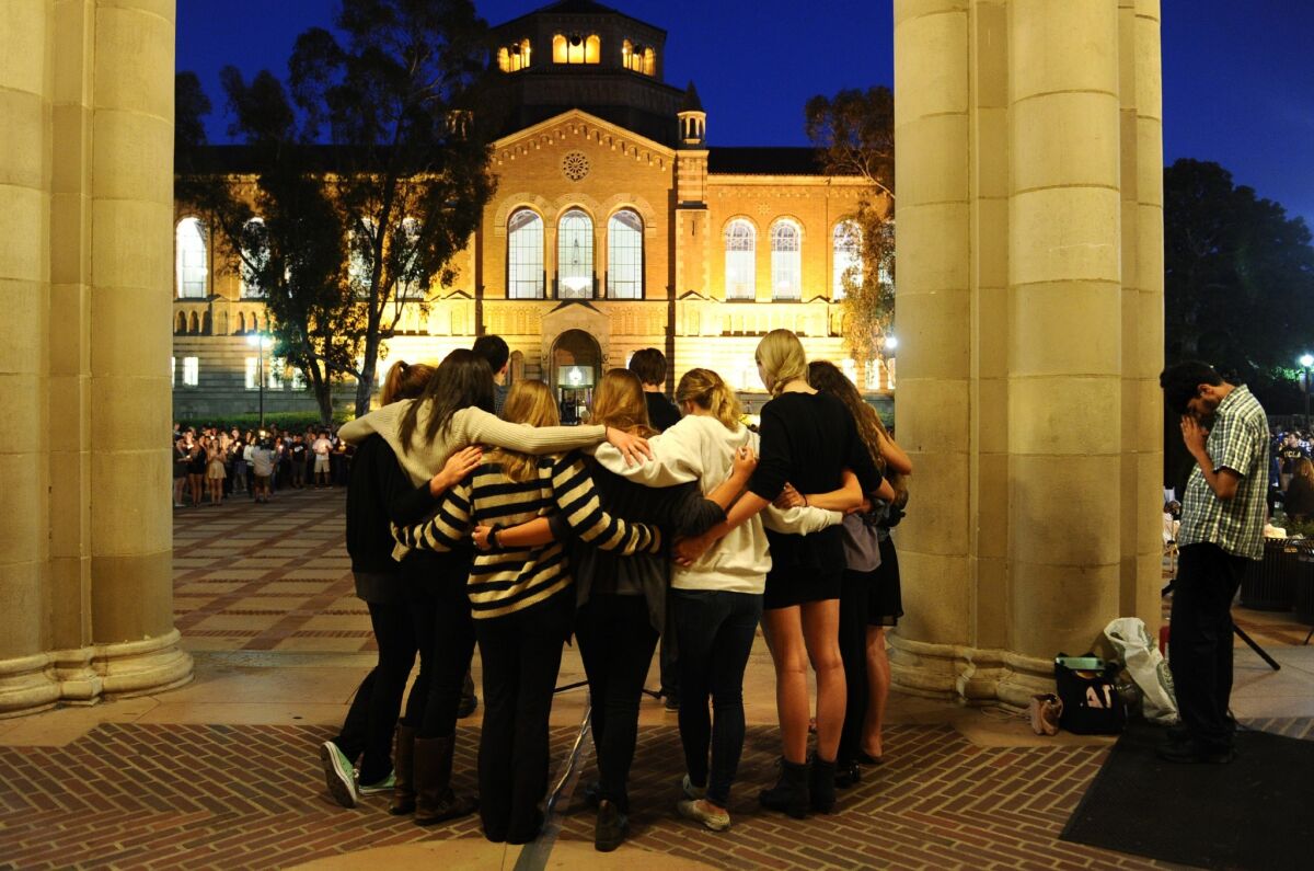 Students observe a moment of silence near Royce Hall at UCLA during a tribute to the Isla Vista victims.