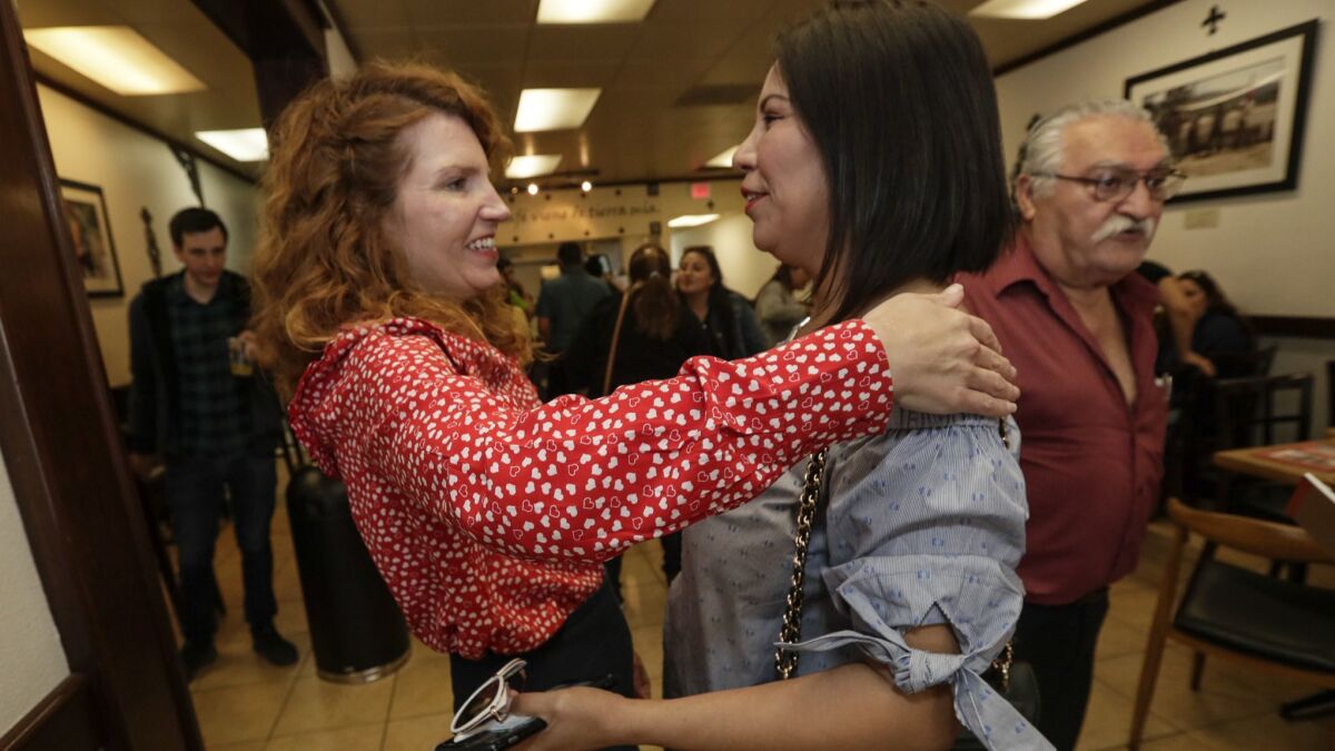 Heather Repenning greets parent Perla Esparza at a meeting with parents and voters at Tierra Mia Coffee in Huntington Park.