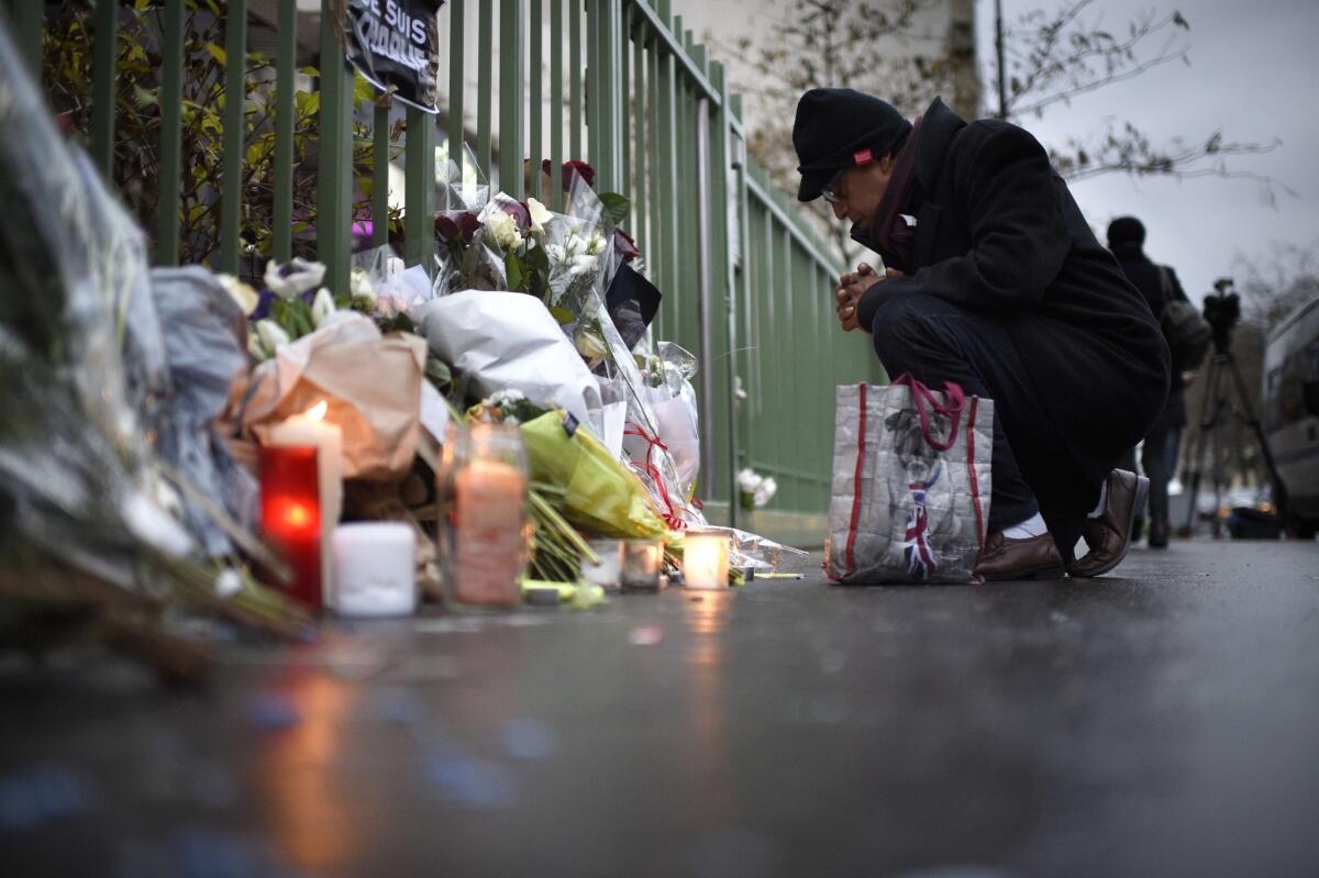 A man reflects at a memorial near the offices of French satirical newspaper Charlie Hebdo the day after the deadly attack.