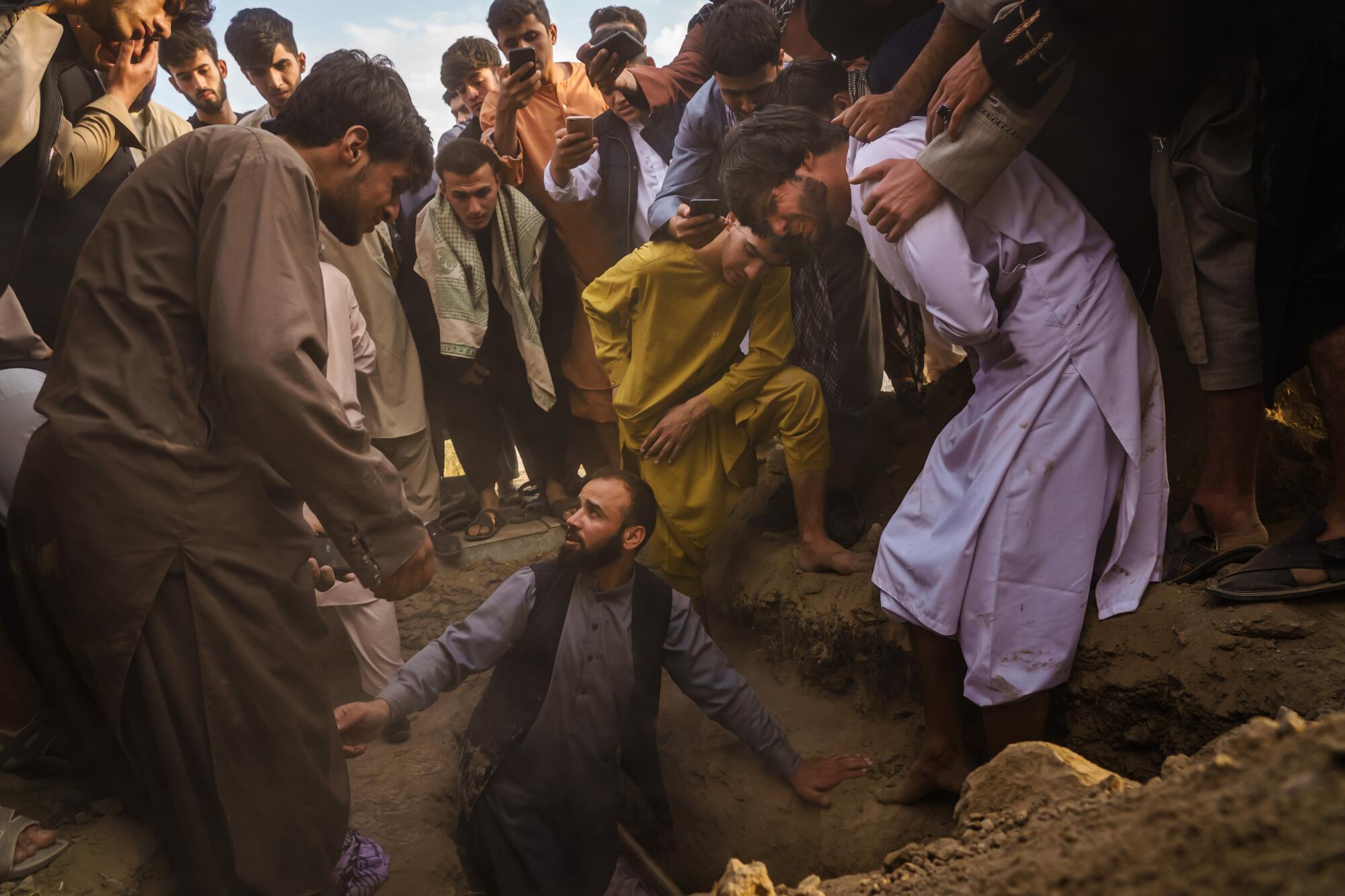 Relatives weep as they bury Nasser Ahmadi, 25