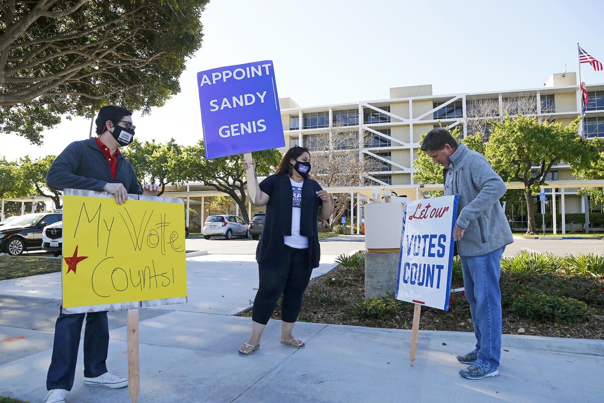 Costa Mesa residents, from left, Ben Chapman, Hengameh Abraham and Dale Luther rally Tuesday at Costa Mesa City Hall.