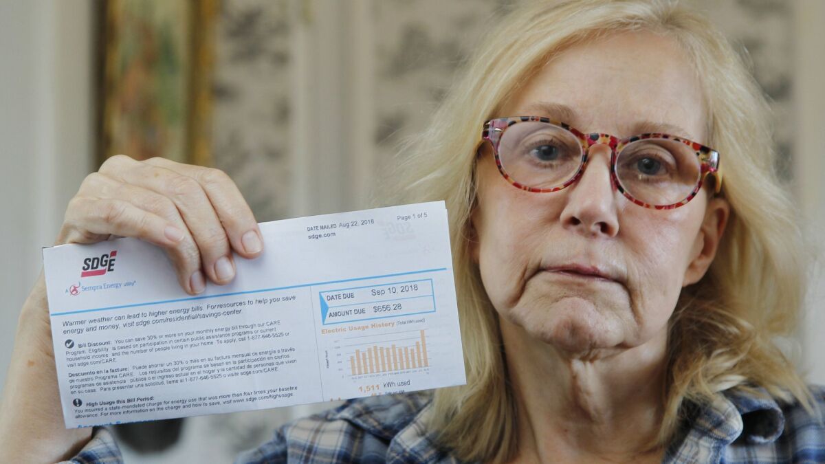 SDG&E customer Georgiana Silvestro holds up her most recent electric bill which totals $656.28 at her home in Fallbrook.