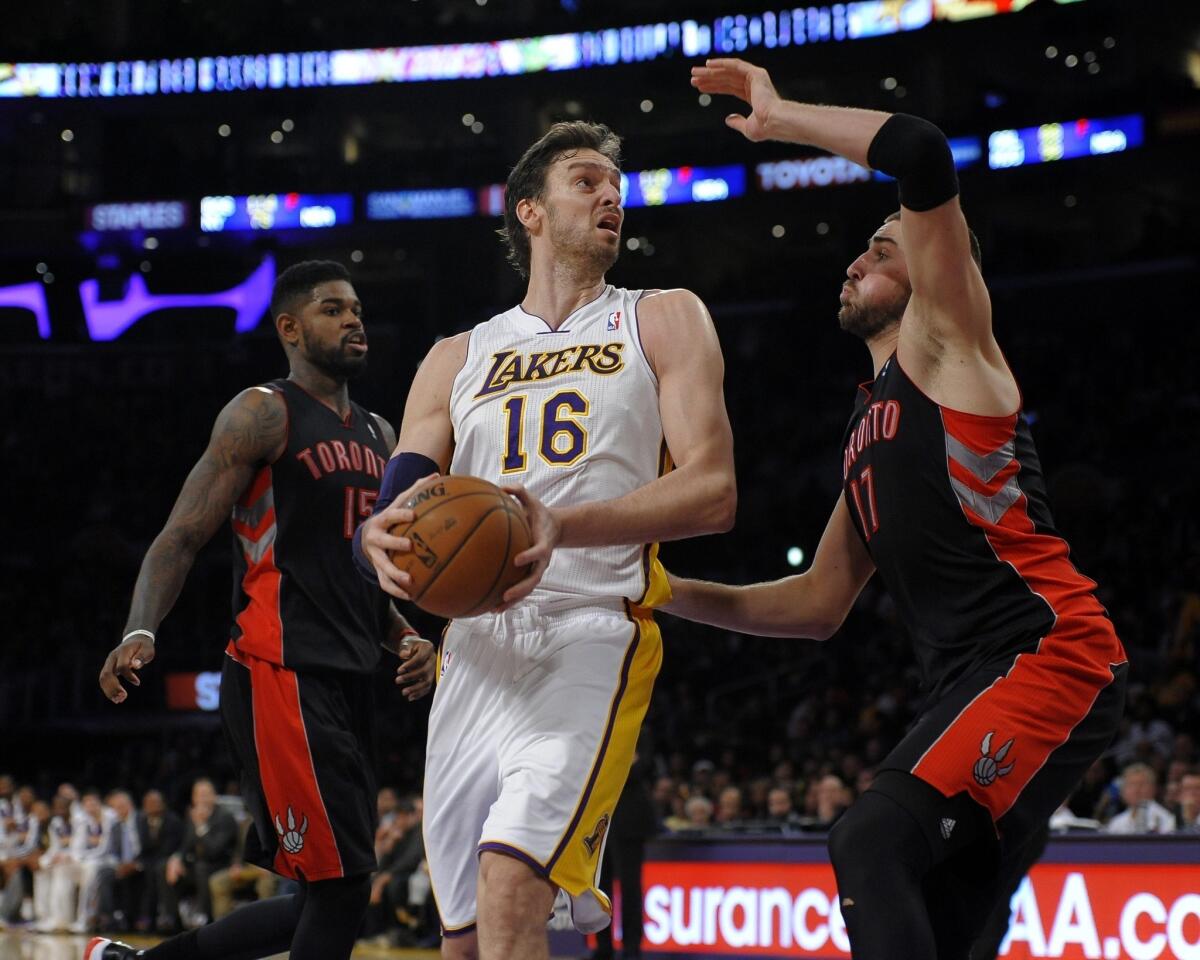 Lakers forward Pau Gasol, left, tries to pass around Toronto's Jonas Valanciunas during Sunday's loss. Gasol has struggled to keep opposing players from racking up points in the paint.