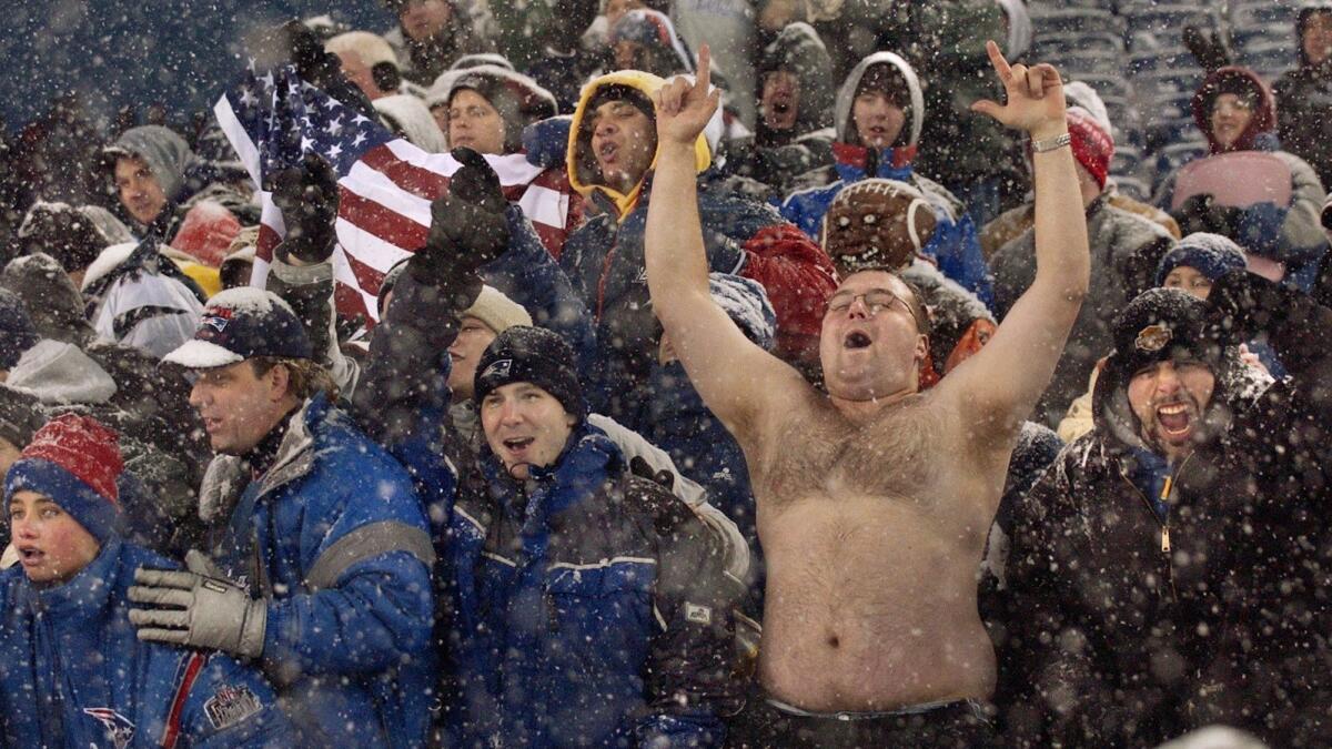 Football fans of the Patriots brave the cold and snow.