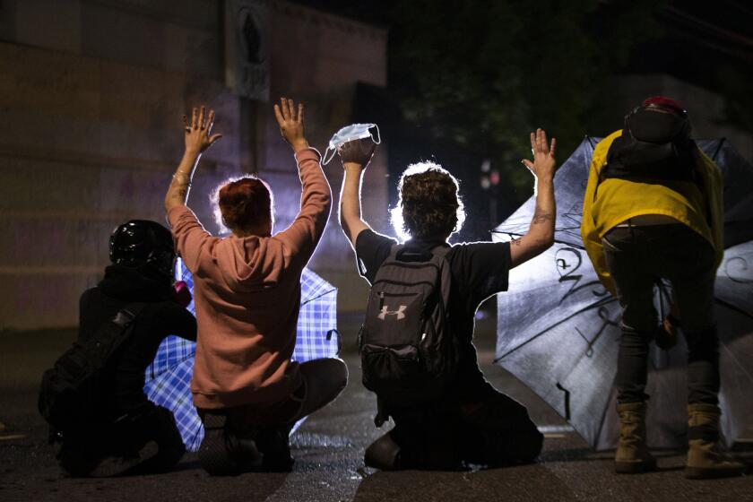 A march on the Portland police union headquarters drew a rapid police response after someone set a fire next to the building. Monday, Aug. 24, 2020. (Beth Nakamura/The Oregonian via AP)