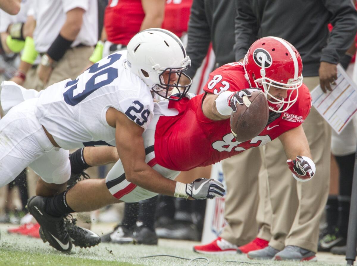 Georgia tight end Jeb Blazevich dives for extra yardage against Penn State cornerback John Reid during first half of the TaxSlayer Bowl on Saturday.