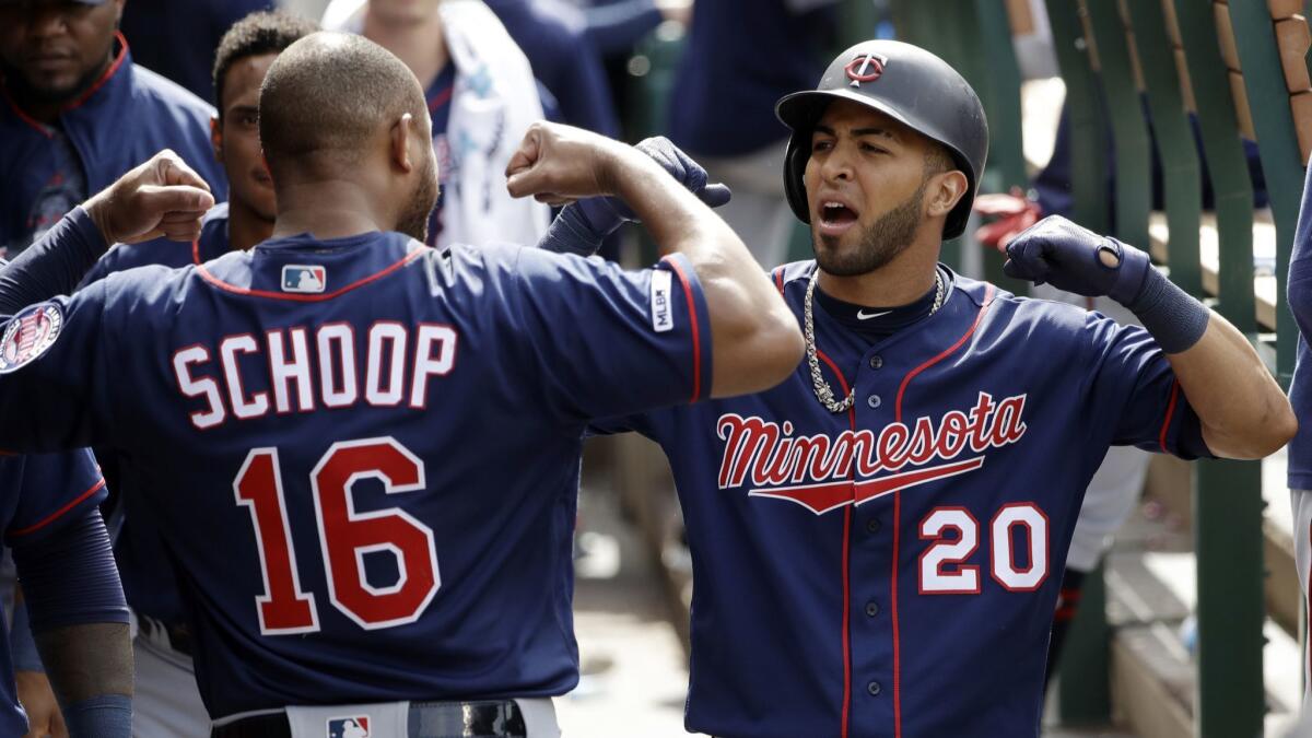 Minnesota Twins' Eddie Rosario, right, celebrates his solo home run with teammate Jonathan Schoop during a game against the Angels on Thursday in Anaheim.