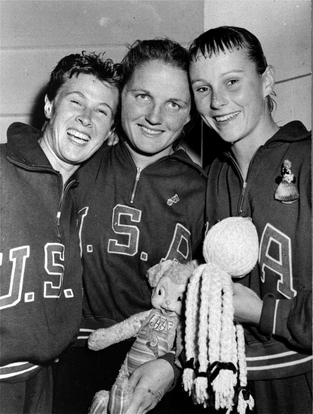 Pat McCormick, center, celebrates with Americans Juno Irwin and Paula Myers after winning diving gold.