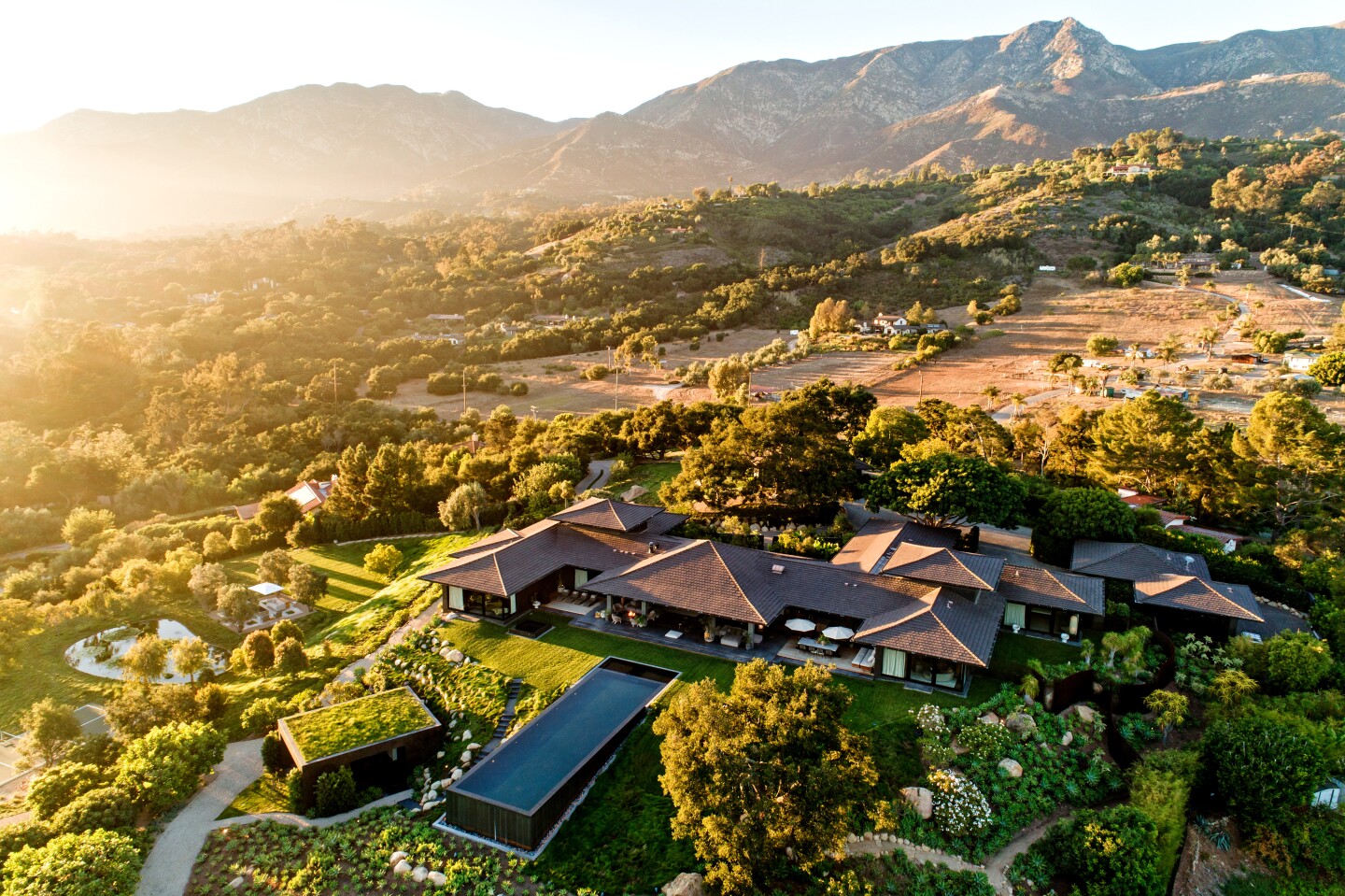 Set against a dramatic backdrop of mountains, the Bali-inspired estate features multiple houses and high-end amenities across nine acres.