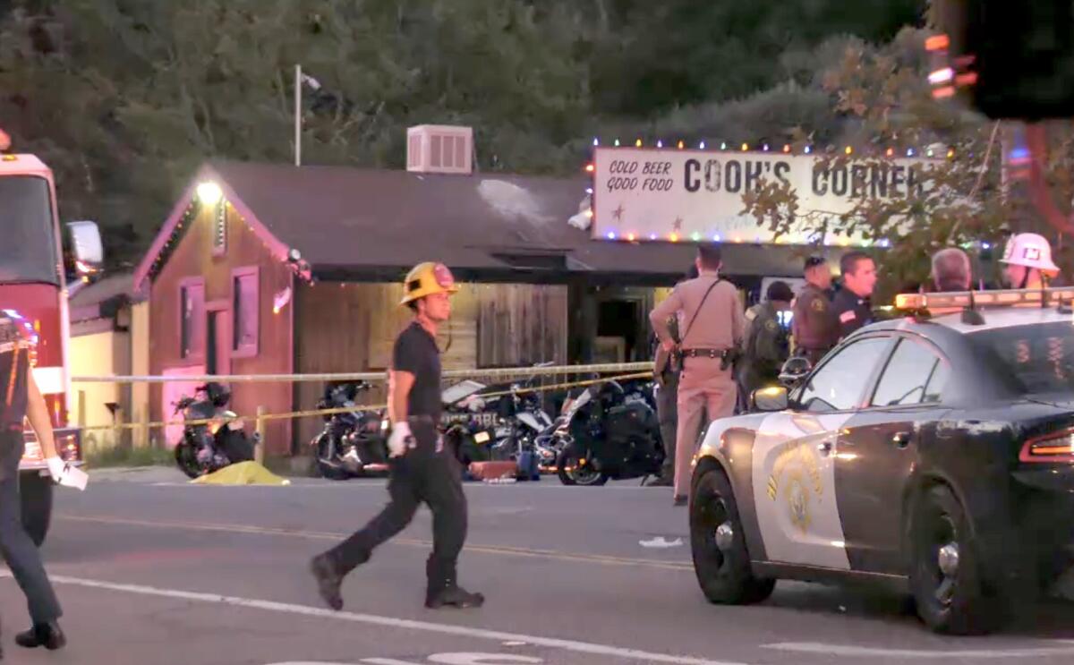 Yellow police tape, police vehicles and law enforcement personnel at Cook's Corner 