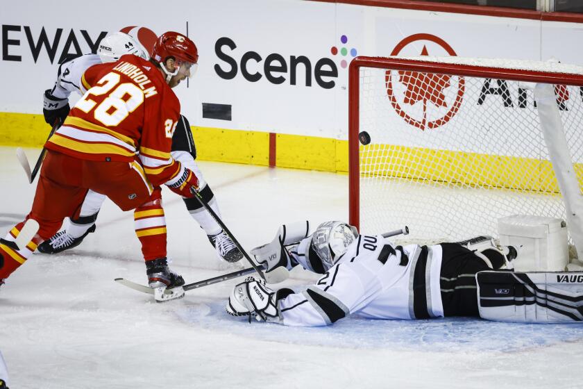Los Angeles Kings goalie Jonathan Quick, right, is scored on by Calgary Flames forward Elias Lindholm.