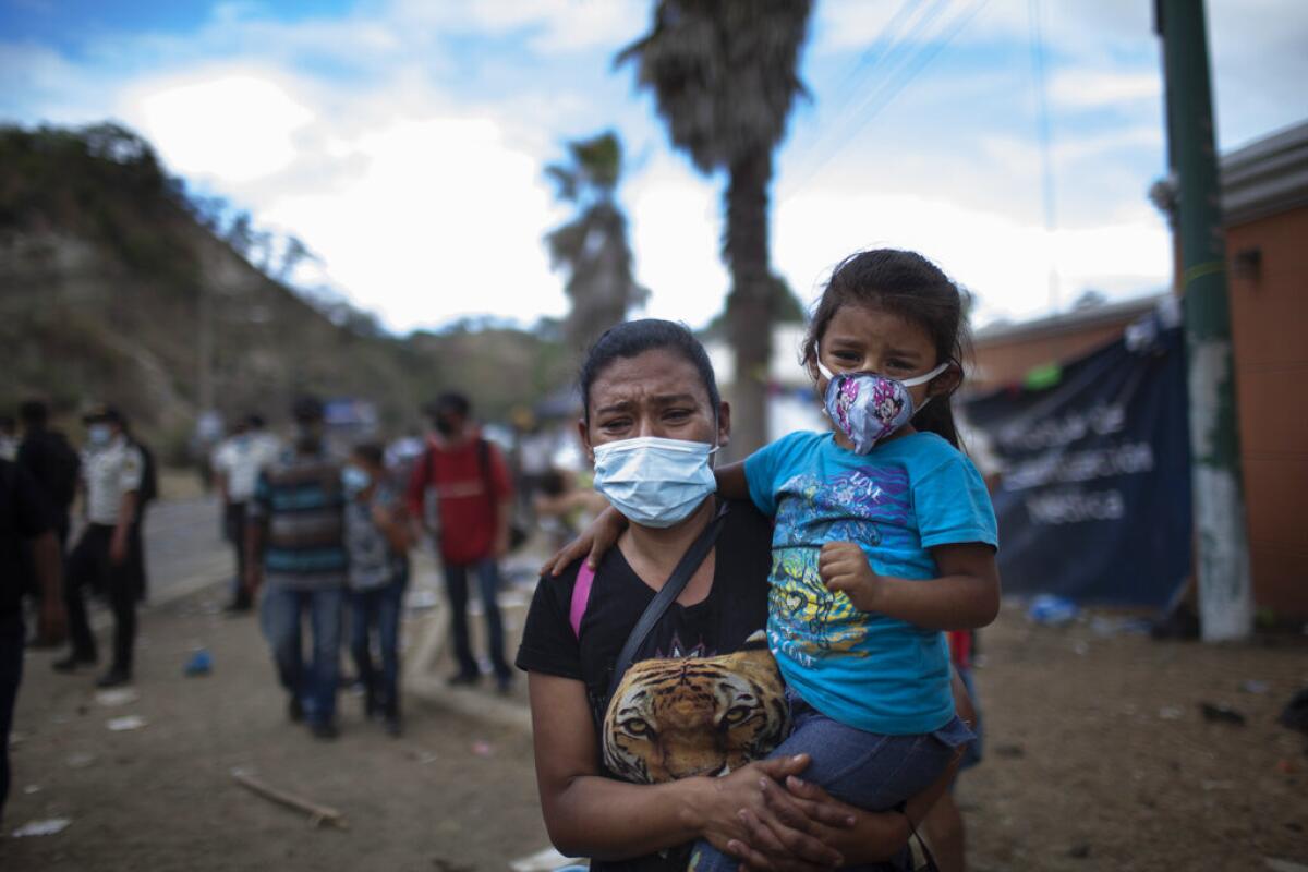 Una mujer y una niña caminan junto a una carretera en Vado Hondo, Guatemala,