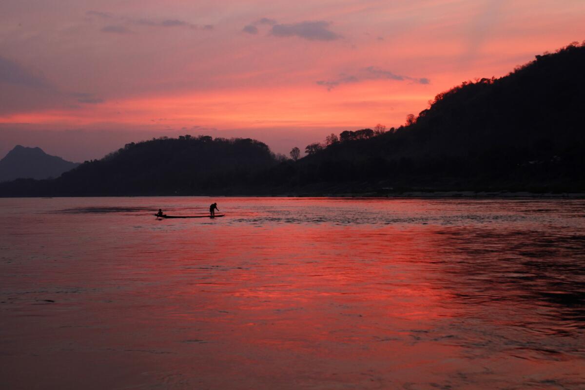 Un hombre cruza en un bote el río Mekong en Luang Prabang, Laos. Este sitio encantador fue declarado patrimonio de la humanidad por la UNESCO hace un par de años y desde entonces se debate entre la explotación comercial de sus atractivos y la preservación de su herencia cultural. (AP Photo/Jacquelyn Martin, File)