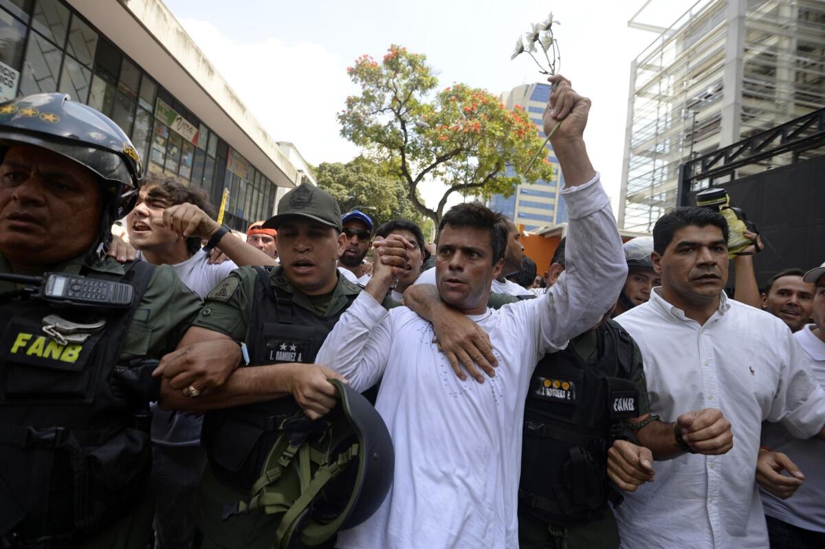 Venezuelan opposition leader Leopoldo Lopez, center, is escorted by national guard members after turning himself in during a demonstration in Caracas.