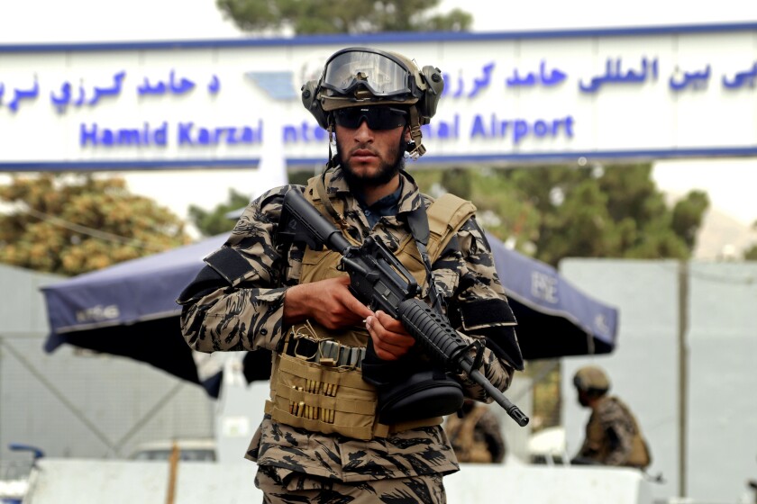 A Taliban fighter stands guard outside Kabul airport.