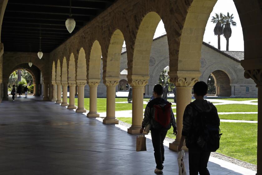 People walk on the Stanford University campus Thursday, March 14, 2019, in Santa Clara, Calif. In the first lawsuit to come out of the college bribery scandal, several students are suing Yale, Georgetown, Stanford and other schools involved in the case, saying they and others were denied a fair shot at admission. The plaintiffs brought the class-action complaint Wednesday, March 13, 2019, in federal court in San Francisco on behalf of themselves and other applicants and asked for unspecified damages. (AP Photo/Ben Margot)