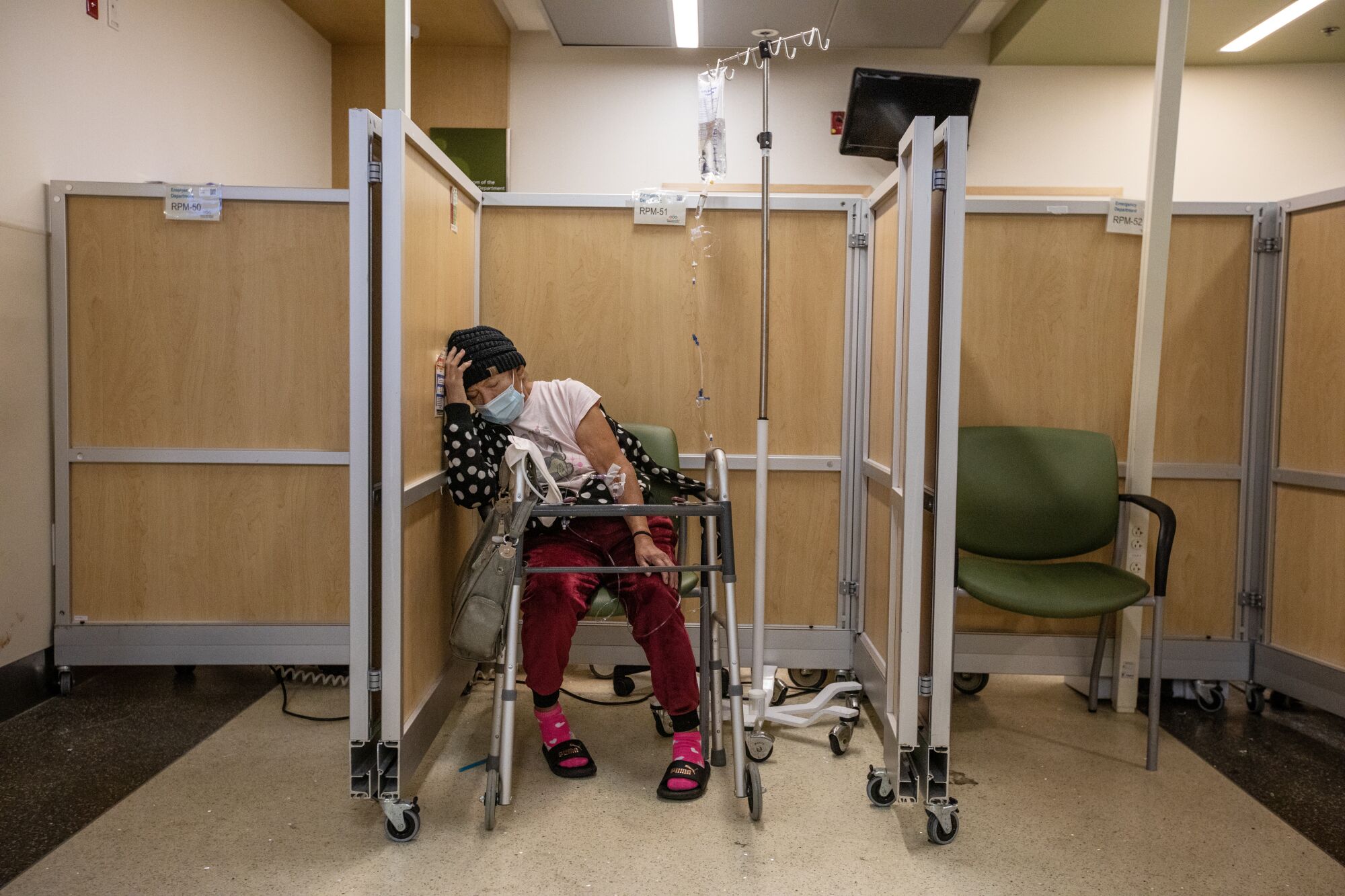 A woman with a walker seated between partitions