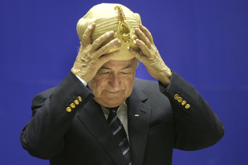 El presidente de la FIFA, Joseph Blatter, se coloca un sombrero tradicional indio el martes, 17 de abril de 2007, en una actividad en Nueva Delhi, India.