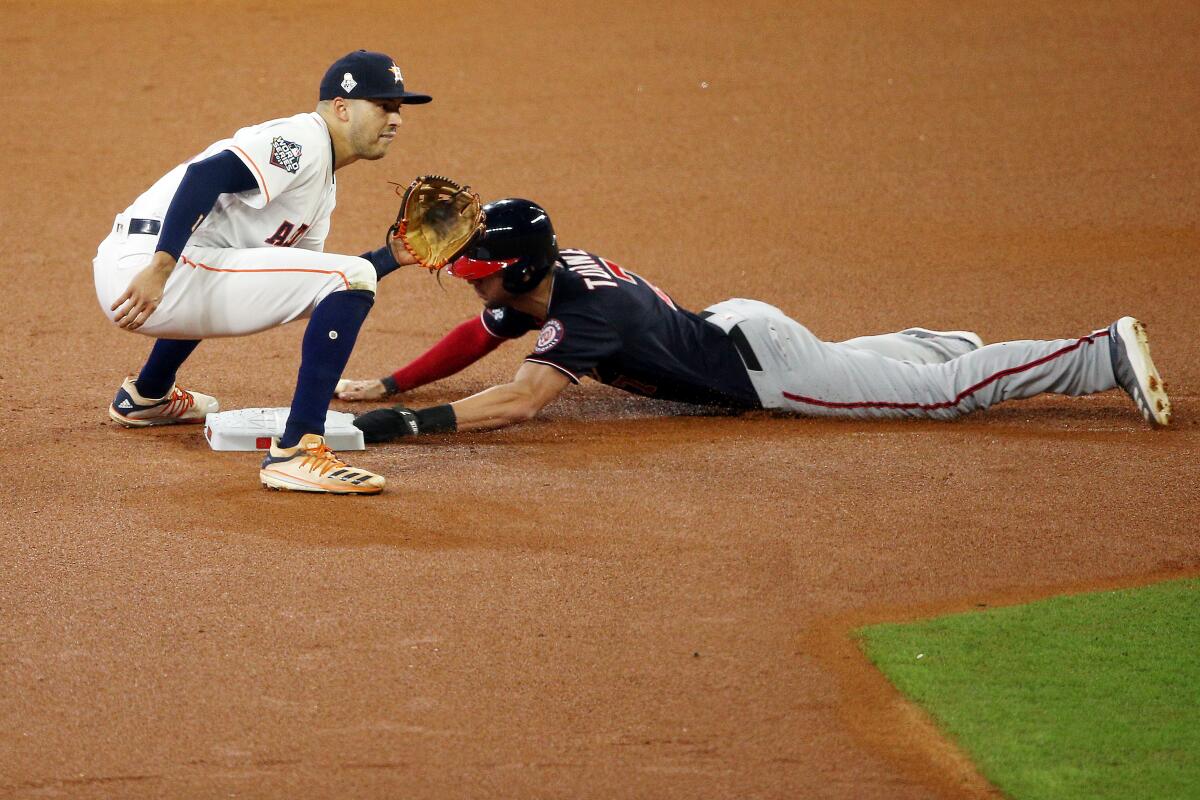 HOUSTON, TEXAS - OCTOBER 22: Trea Turner #7 of the Washington Nationals slides in safely to second base with a stolen base past Carlos Correa #1 of the Houston Astros during the first inning in Game One of the 2019 World Series at Minute Maid Park on October 22, 2019 in Houston, Texas. (Photo by Bob Levey/Getty Images) ** OUTS - ELSENT, FPG, CM - OUTS * NM, PH, VA if sourced by CT, LA or MoD **
