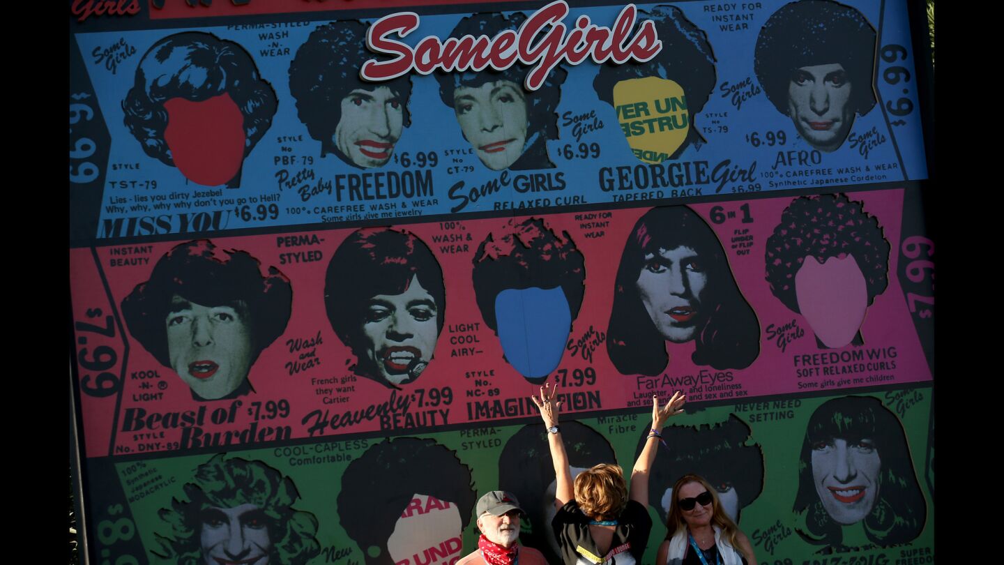 Fans pose for photos under a large reproduction of the Rolling Stones' "Some Girls" album.
