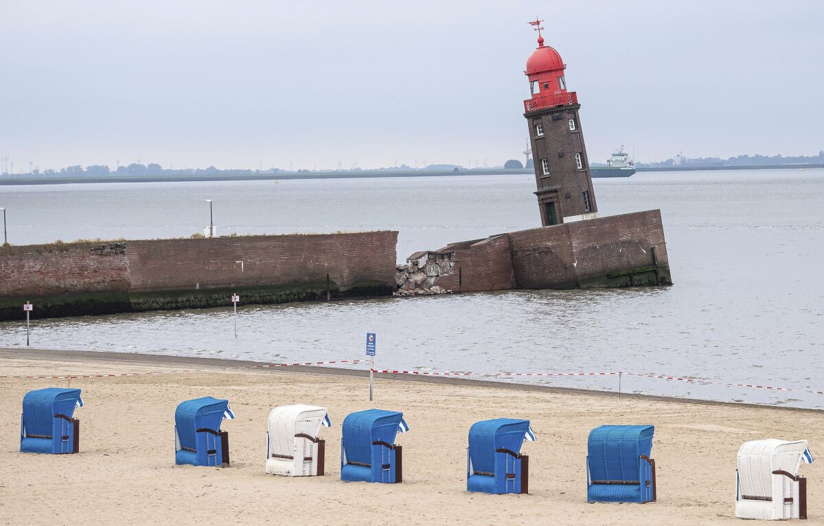 Beach chairs stay on the beach next to the leaning Mole tower in Bremerhaven, Germany, Thursday, Aug. 18, 2022. Officials in Bremen said Thursday that an iconic lighthouse at the German city’s port has tilted sideways and could soon topple over entirely. (Sina Schuldt/dpa via AP)
