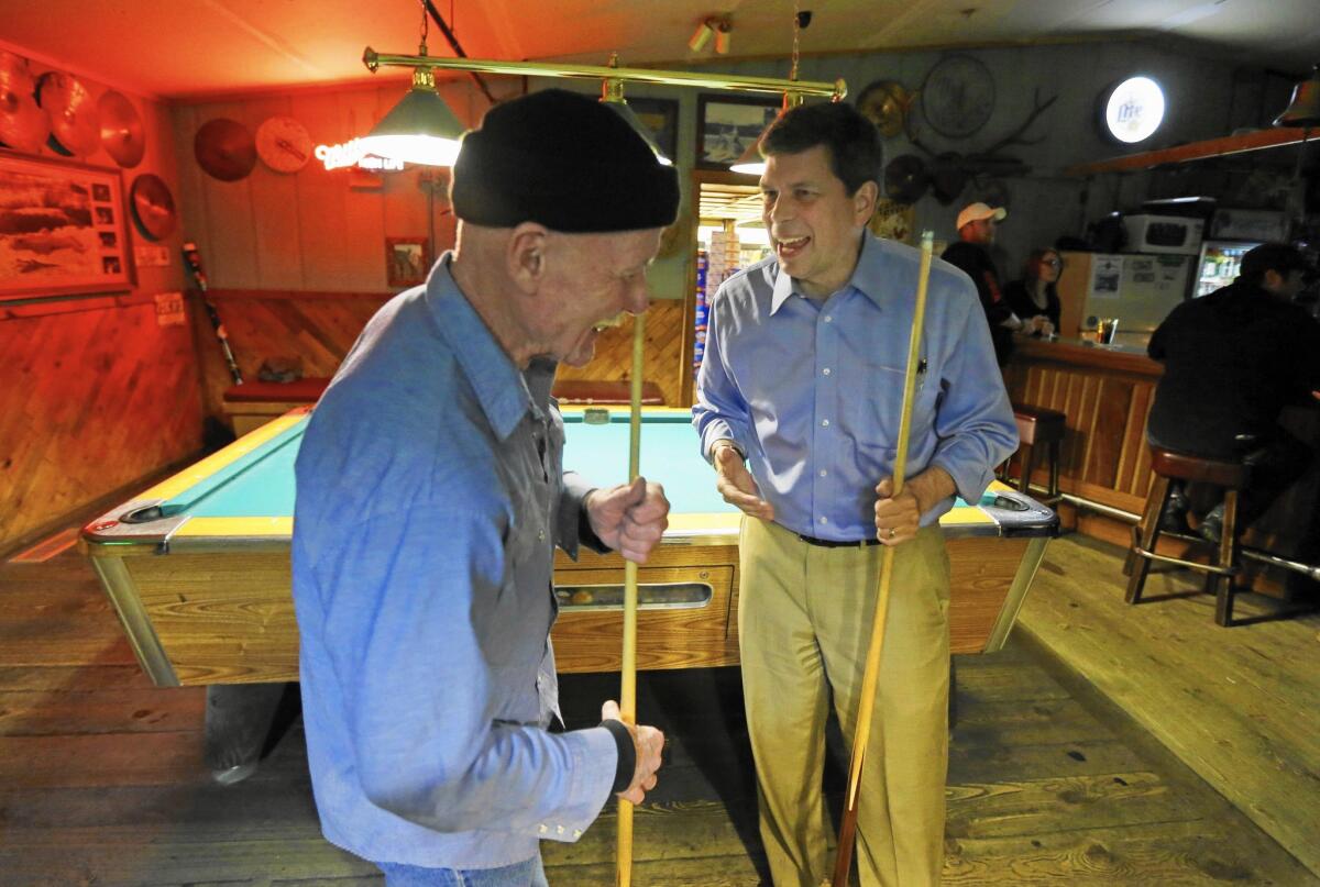 Democratic Sen. Mark Begich, right, jokes with Jimmy Maddox this month at Kito's Kave, a bar in Petersburg, Alaska.